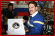 Grunsfeld holds up the Shuttle/Mir program photo to show the crew signatures